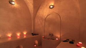 A spa room with a bathtub, candles, and a shelf with shoes. - Riad Zineb (Marrakech)
