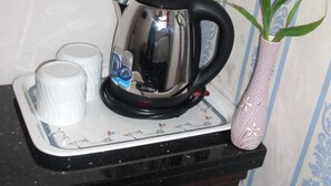 Eine Küchenarbeitsplatte mit einem Wasserkocher, einer Tasse und einer dekorativen Vase.