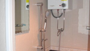 Ein Badezimmer mit Waschbecken, Toilette und Dusche inklusive Handbrause.