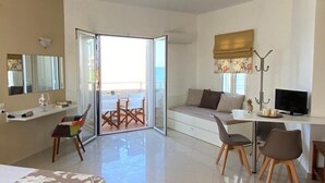 Ett modernt hotellrum med en säng, ett skrivbord, en soffa och en balkong.