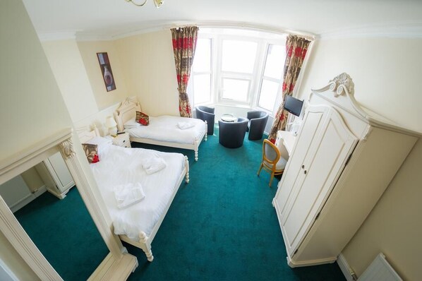 A hotel room with two beds, a desk, a chair, and a wardrobe. - Queensbridge Hotel (Aberystwyth)