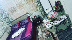 A room with a bed, a small table with a basket, and a chair. - Hidirlik Pansiyon (Antalya)