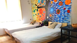 A room with two wooden beds, white bedding, a glass table, and a colorful abstract painting on the wall. - Weihai Hiking International Youth Hostel (Weihai)