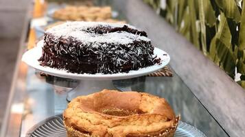 Una mesa de bufé con diversos postres, incluyendo un pastel de chocolate, un pastel roseta y pastelería enrollada.