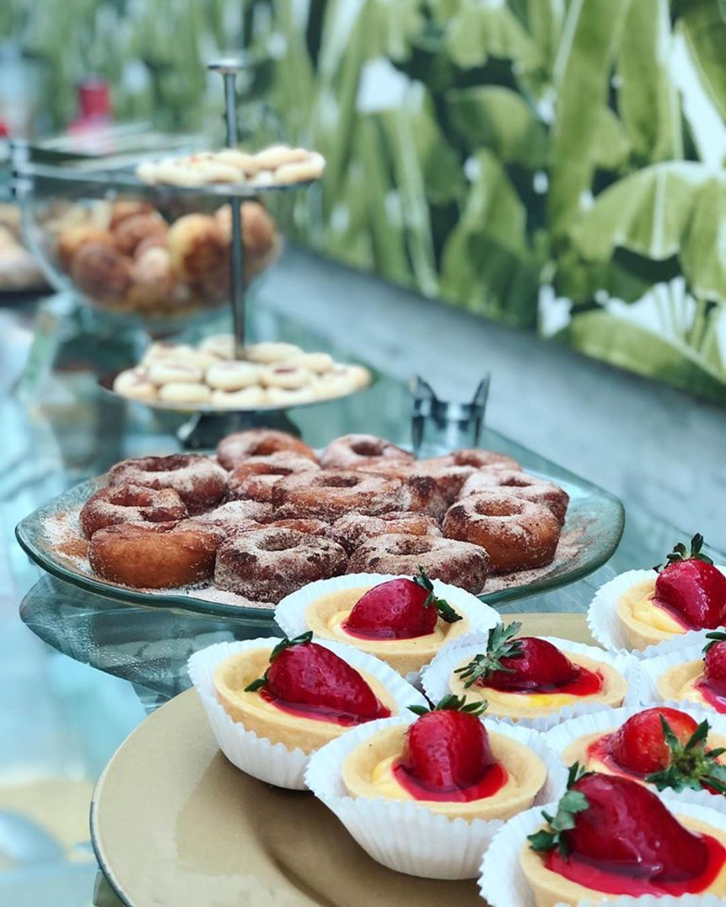 A buffet table with various desserts including donuts, tarts, and pastries.