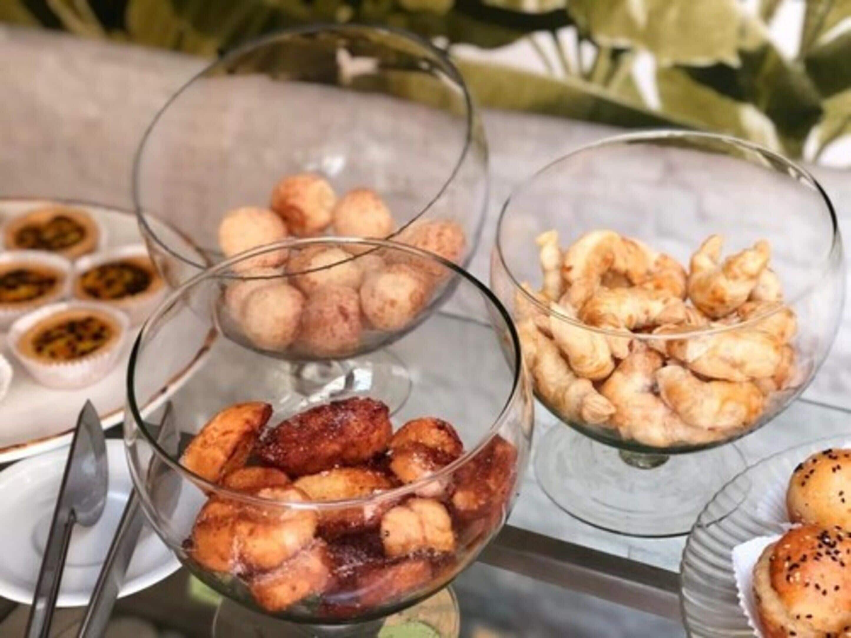 Drie glazen schalen met verschillende soorten lekkernijen, waarschijnlijk een dessert of tussendoortje.