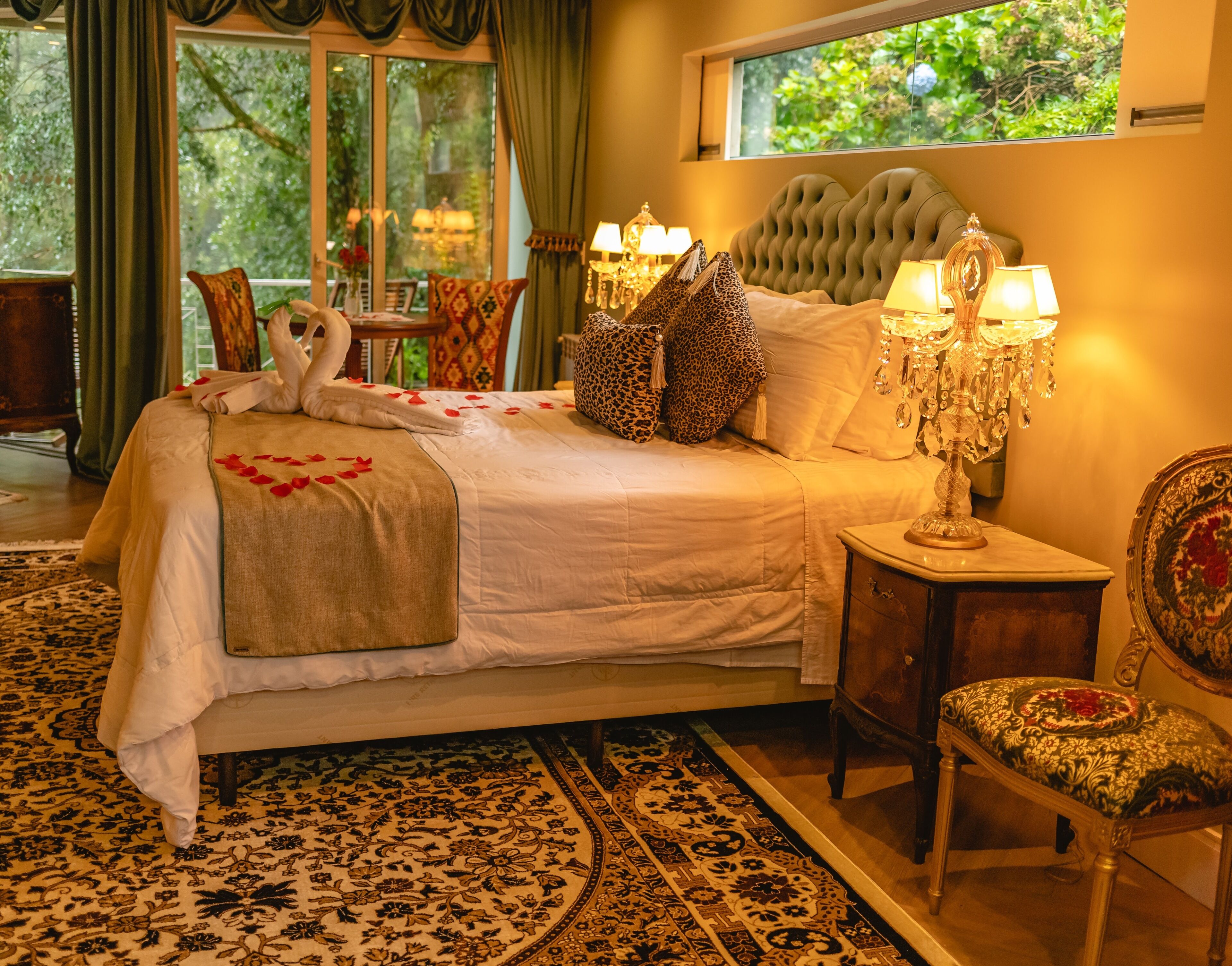 Un dormitorio elegante con una cama grande, lámparas ornamentales y vistas al exterior.