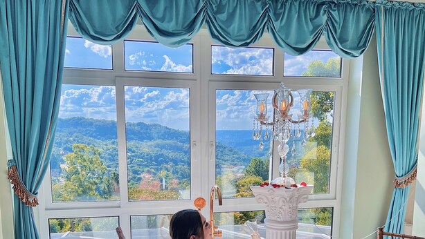 A room with a large bathtub, a view of a mountainous landscape, and a chandelier. - Le Boutique Hotel Gramado - Exclusivo para Casais (Gramado)
