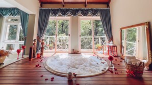 A room with a hot tub, large windows, and a chandelier. - Le Boutique Hotel Gramado - Exclusivo para Casais (Gramado)