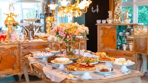 A buffet table with various desserts and a chandelier. - Le Boutique Hotel Gramado - Exclusivo para Casais (Gramado)