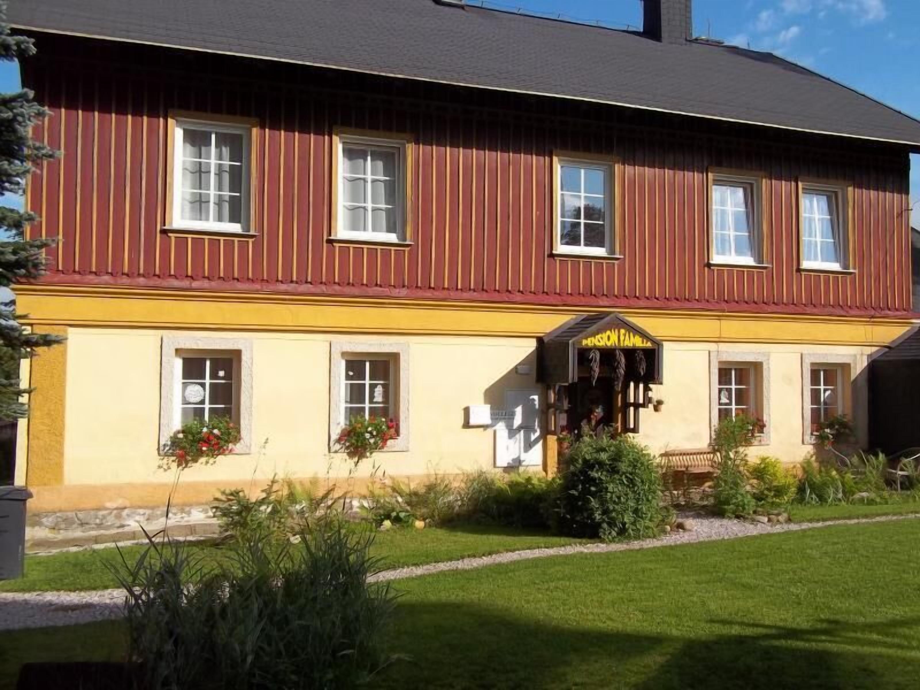 Un bâtiment à deux étages avec une façade jaune et des ornements rouges.