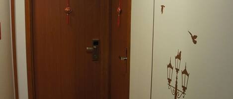 A hallway with a wooden door marked '1107' and an emergency exit sign above it.
