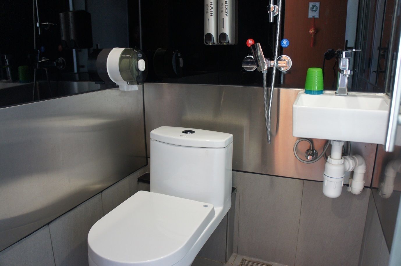 A compact bathroom with a white toilet, a sink, and a shower.
