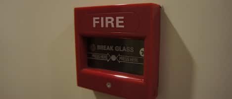 A red fire alarm control panel mounted on a wall.