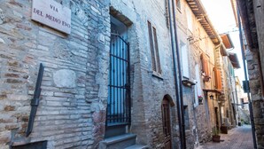A narrow cobblestone street with historic stone buildings, a sign reading "VIA DEL MEDIO EVO," and a staircase leading to a door. - Assisivm Antica Dimora AD (Assisi)