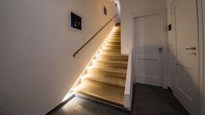 A staircase with wooden steps leading to a white door. - Assisivm Antica Dimora AD (Assisi)
