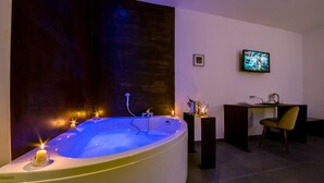 A modern bathroom with a large bathtub, a small desk, and a television. - Assisivm Antica Dimora AD (Assisi)