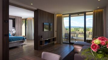 Une chambre d’hôtel moderne dotée d’un grand lit, d’une télévision, d’un balcon avec vue et d’un coin repas.
