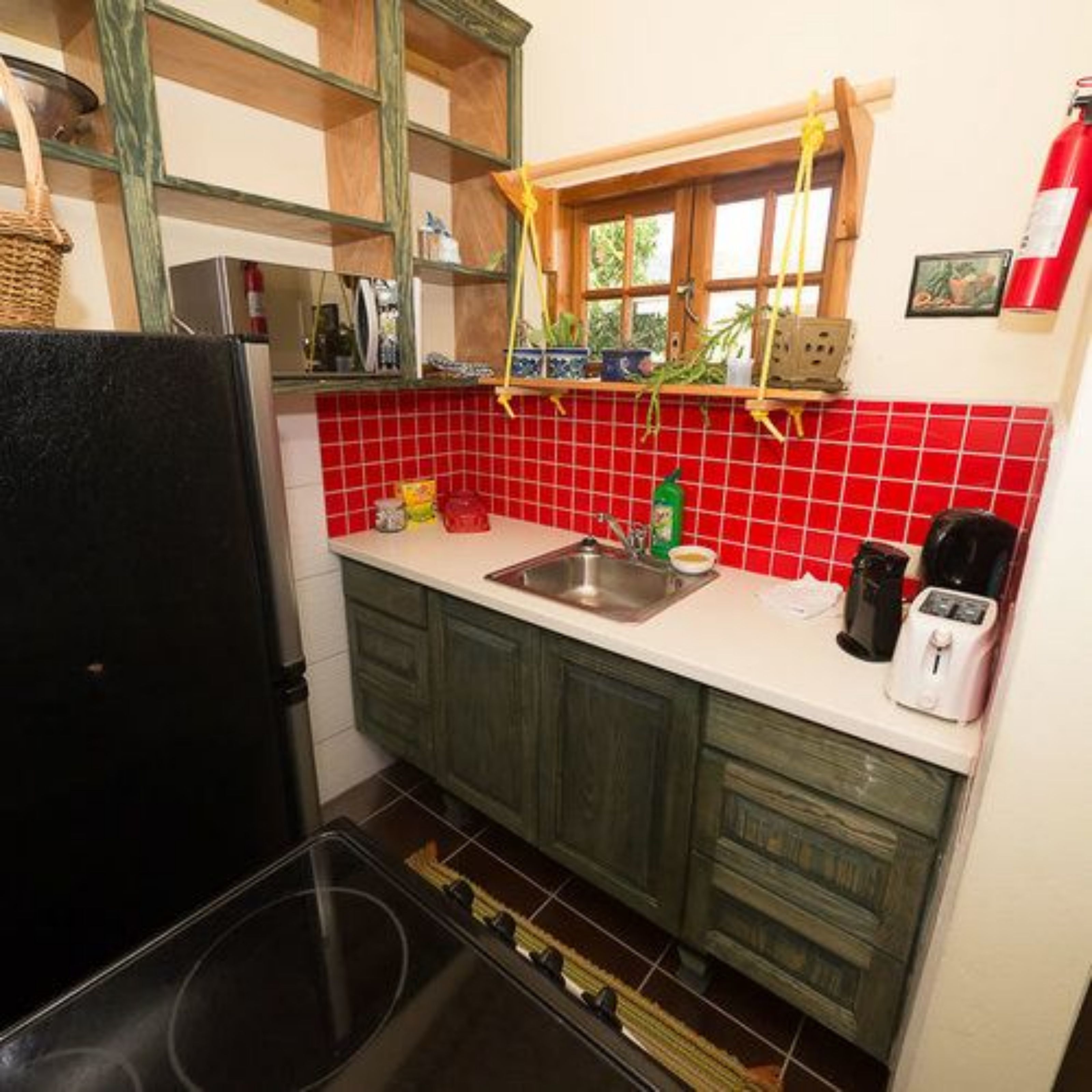 A compact kitchen with a sink, a toaster, and a stove.