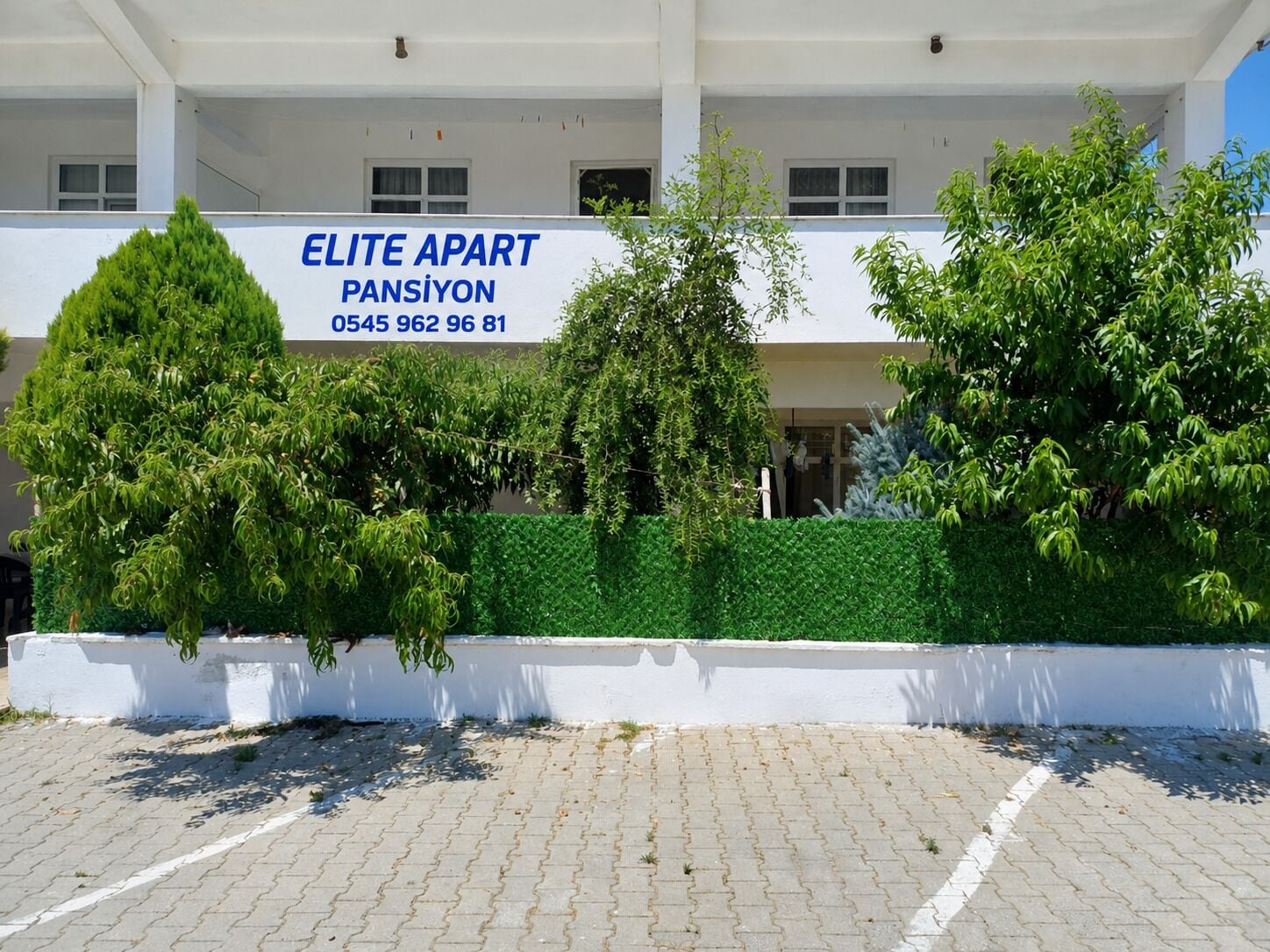 A building with a sign reading 'ELITE APART PANSİYON 0545 962 96 81'.