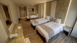 A hotel room with two beds, a bedside table, a phone, and a mirror. - Mass Paradise Hotel (Aqaba)