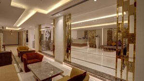 A modern lobby with a reception desk, seating area, and decorative panels. - Mass Paradise Hotel (Aqaba)