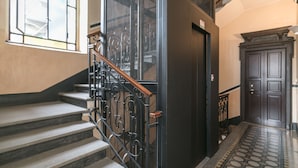 A staircase with metal railings and a patterned floor leading to a dark wooden door. - notaMi -  Borsieri 29 (Milan)