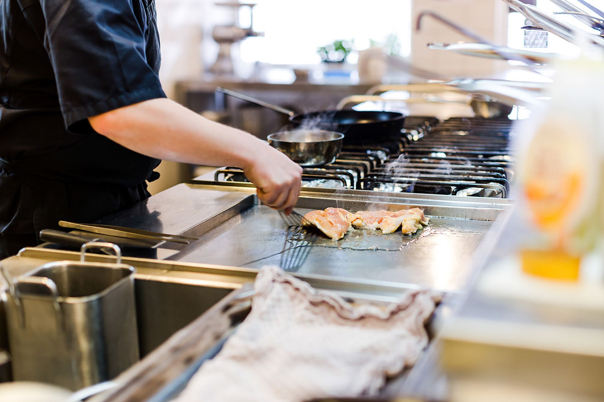 A kitchen with a grill and cooking utensils.