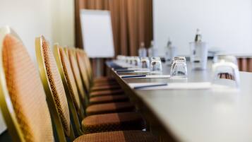A conference room with a long table, chairs, and water glasses.