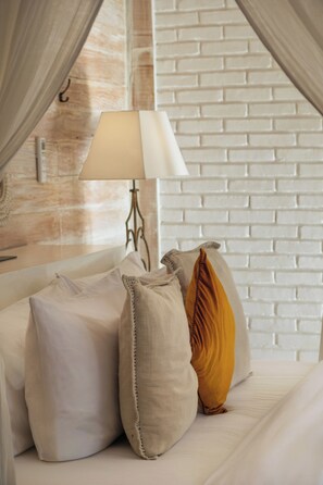 A bed with a white headboard, a lamp, and several pillows. - Mannao Estate by Villa Finder (Kerobokan)