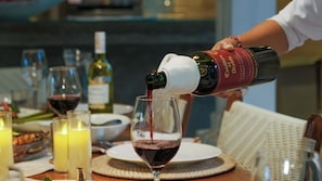 A bottle of wine being poured into a glass. - Mannao Estate by Villa Finder (Kerobokan)