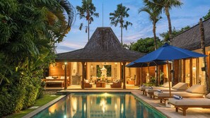 A poolside area with lounge chairs and a covered seating area. - Mannao Estate by Villa Finder (Kerobokan)