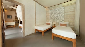 A hotel room with two single beds, a wooden headboard, a decorative wall panel, and a bathroom visible through an open door.
