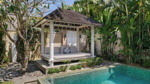 A covered outdoor seating area with a pool. - Mannao Estate by Villa Finder (Kerobokan)