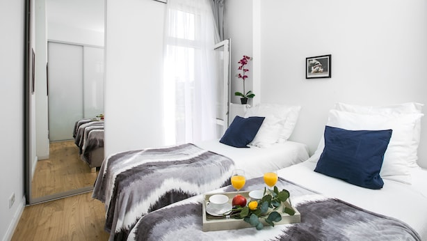 A hotel room with a bed, bedside table, and a mirror. - Otium Old Town Łobzowska (Kraków)