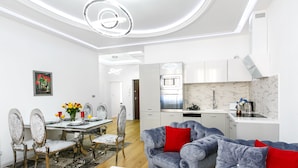 A modern kitchen with white cabinets, a built-in oven, and a microwave. - Otium Old Town Łobzowska (Kraków)