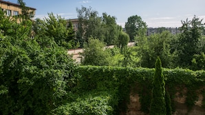 A lush green landscape with dense foliage and a building in the background. - Otium Old Town Łobzowska (Kraków)