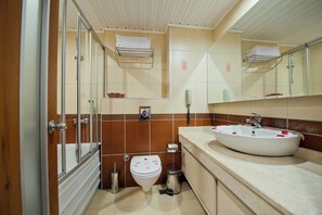 Une salle de bain avec une baignoire, des toilettes, un lavabo et un miroir.