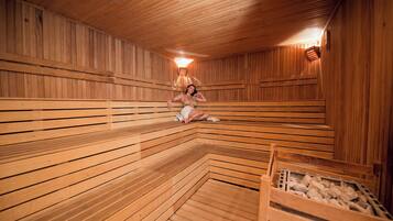 A sauna with wooden benches and a stone floor.