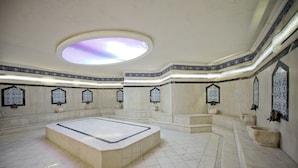 A spacious room with a large central area, a skylight, and decorative wall tiles. - Beach Club Doganay (Alanya)