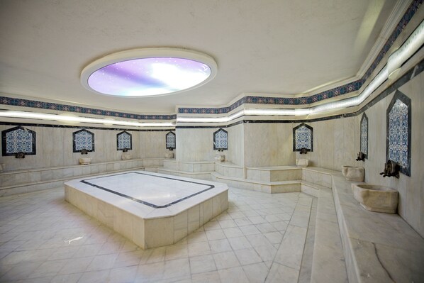 A spacious room with a large central area, a skylight, and decorative wall tiles.