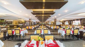 A spacious dining area with multiple tables, chairs, and a central decorative element.
