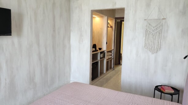 A bedroom with a bed, a small table, and a wardrobe.