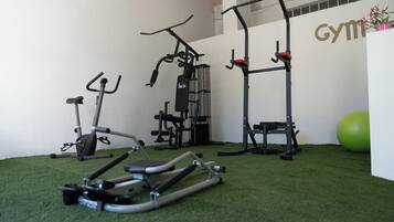 A gym with exercise equipment including a stationary bike, elliptical, and a pull-up bar.