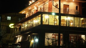 A multi-story building with balconies, large windows, and a staircase. - Archontiko Tzoumerkon (Central Tzoumerka)