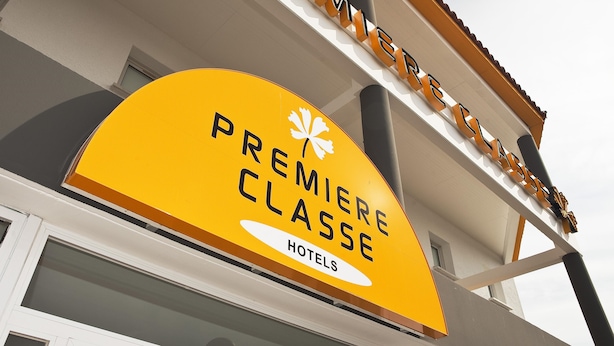 Une enseigne d’hôtel avec l’inscription « PREMIÈRE CLASSE HÔTELS ».