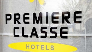 Une fenêtre ornée du logo de la chaîne hôtelière Premiere Classe.