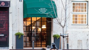 Een restaurant met een groen luifel waarop 
