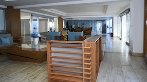 A spacious lobby with a modern reception desk, seating area, and a view of the hallway. - Las Olas by Destinos 1A (Guayacanes)