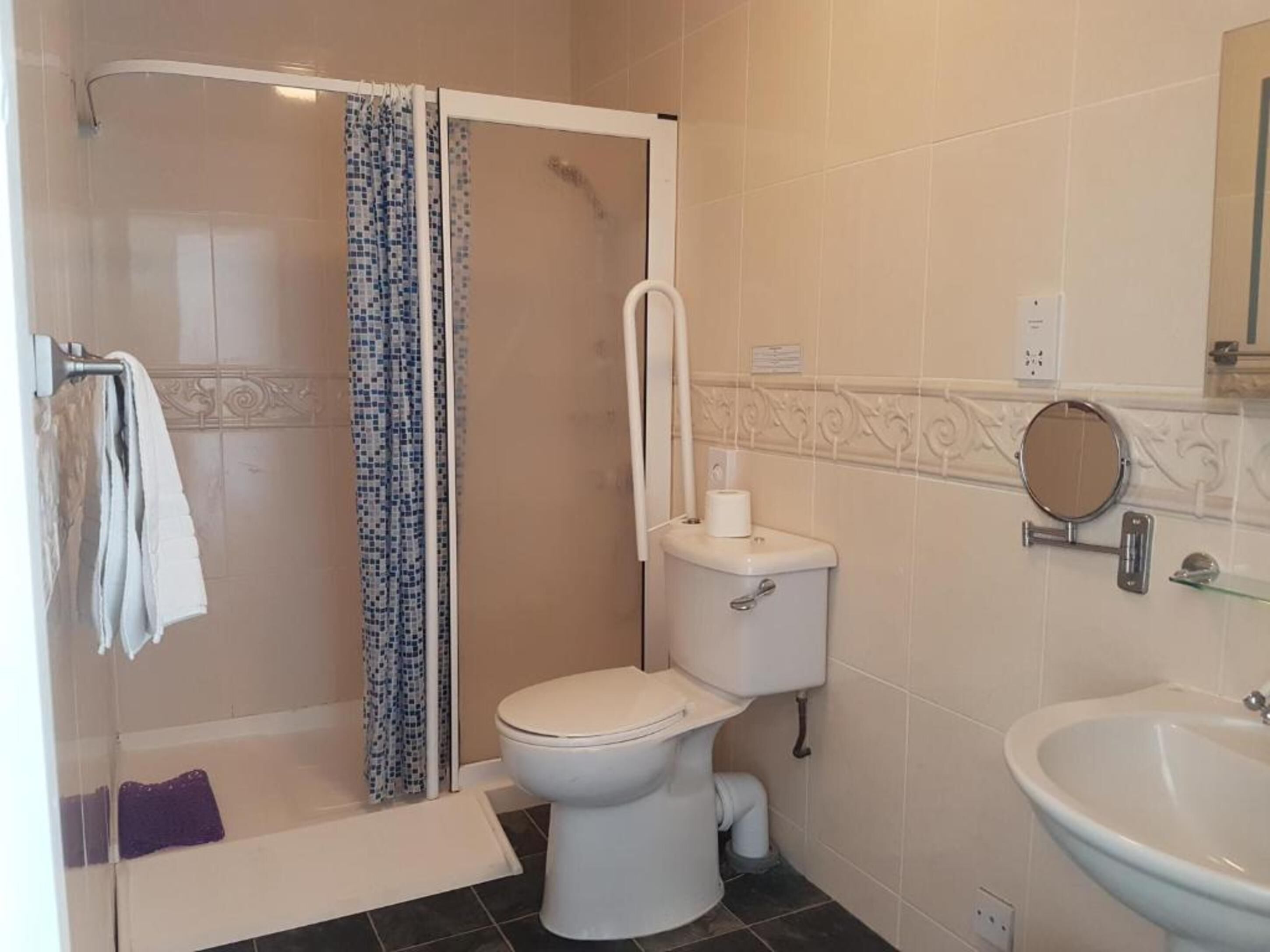 A bathroom with a shower, toilet, and sink.